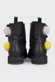 Black leather boots decorated with pom-poms