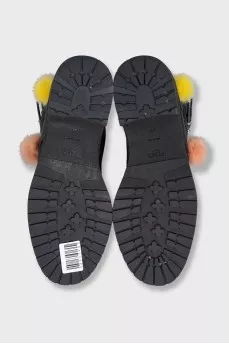 Black leather boots decorated with pom-poms
