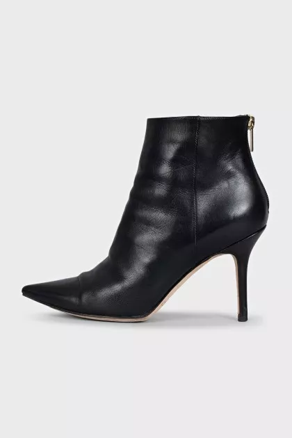 Black leather ankle boots with a gold zipper