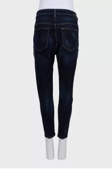 Dark blue tapered fit jeans with a distressed effect