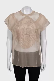 A loose-fitting, transparent blouse decorated with embroidery