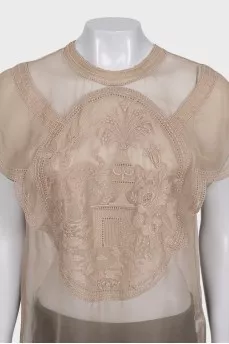 A loose-fitting, transparent blouse decorated with embroidery