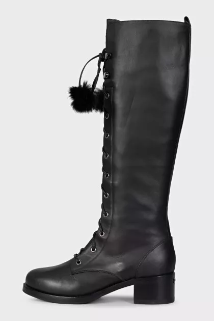 Black leather boots decorated with pom-poms