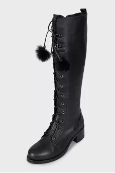 Black leather boots decorated with pom-poms