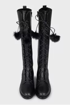 Black leather boots decorated with pom-poms