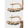 Gold earrings decorated with emeralds