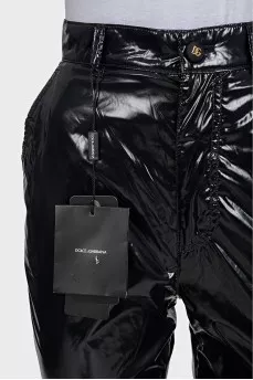 Black patent leather trousers with tag