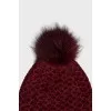 Red knitted hat with a pompom