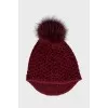 Red knitted hat with a pompom