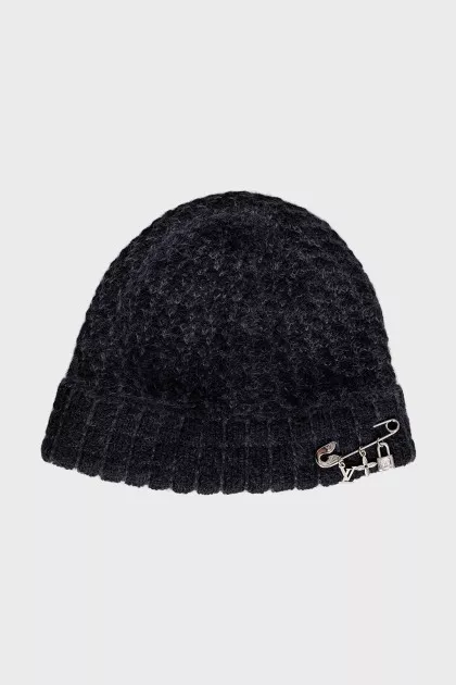 A hat decorated with a pin and pendants