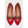 Red leather shoes decorated with a bow