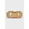 A chunky gold bracelet with a tag
