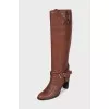 Brown boots decorated with a strap