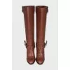 Brown boots decorated with a strap