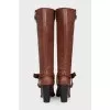 Brown boots decorated with a strap