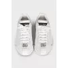 White sneakers with a silver logo