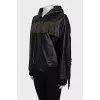 The leather jacket is decorated with fringe and a tag.