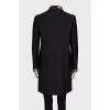 The black coat is decorated with a golden logo.