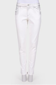 White jeans with a silver coating, with a tag