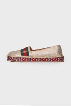 Golden slip-ons with branded appliqué