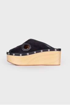 Suede clogs on a wooden platform
