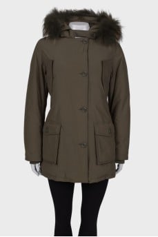 Green parka with fur on the hood with a tag