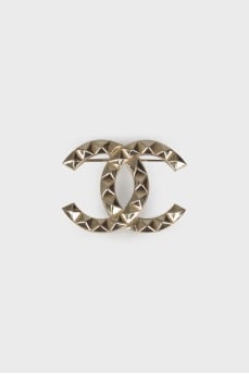 Brooch in the shape of the brand logo