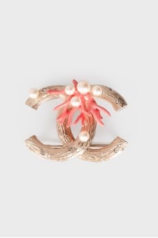 Brooch in the shape of the brand logo