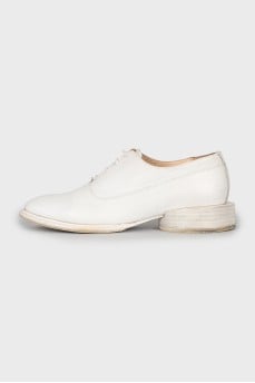 White leather shoes with a figured heel