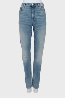 Jeans decorated with embroidered patches
