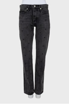 The jeans are decorated with embroidery and a tag