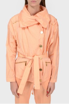 A peach short cloak with an asymmetric fastener on buttons
