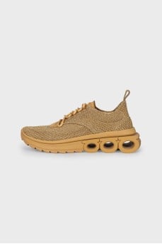 Golden sneakers with a figured sole
