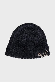 A hat decorated with a pin and pendants