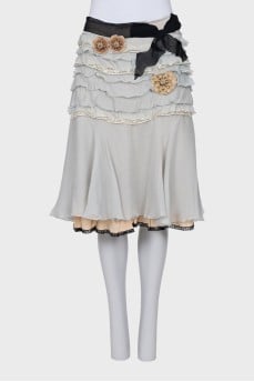 Skirt with frills decorated with brooches