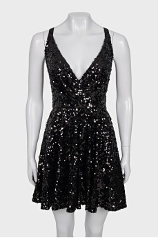 The dress is sleeveless and decorated with sequins