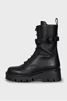 Black boots with a signature logo on the strap