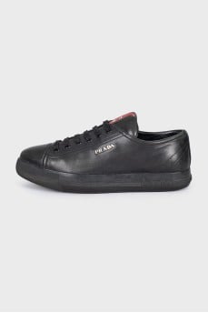 Black leather sneakers with a signature logo