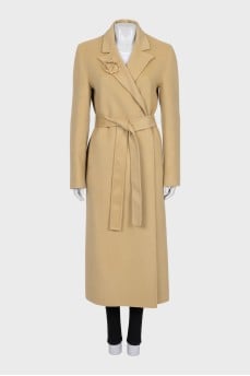 Beige coat with a signature brooch