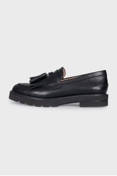 Black leather loafers decorated with tassels