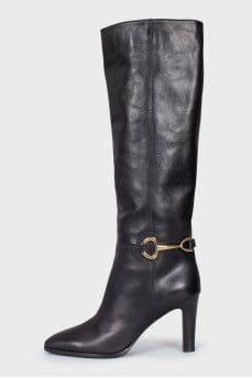 Black leather boots with a gold buckle