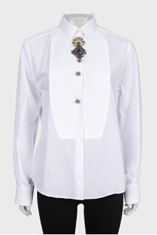 The white shirt is decorated with crystals