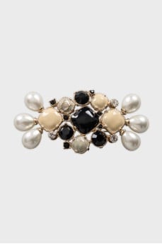 Golden decorated brooch with logo
