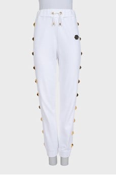 White trousers with gold studs and tag