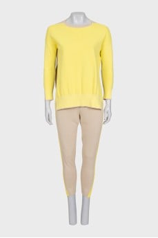 A suit consisting of a jumper with slits and trousers