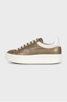 Gold sneakers with white soles