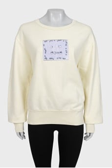Yellow sweatshirt with a patch on the front
