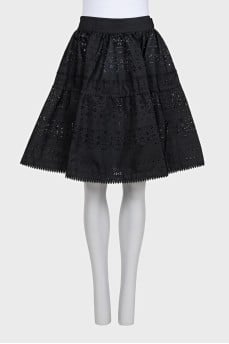 The black skirt is decorated with perforations.