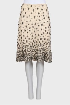 The beige skirt is decorated with sequins