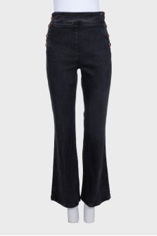 Flared jeans with gold buttons on the side